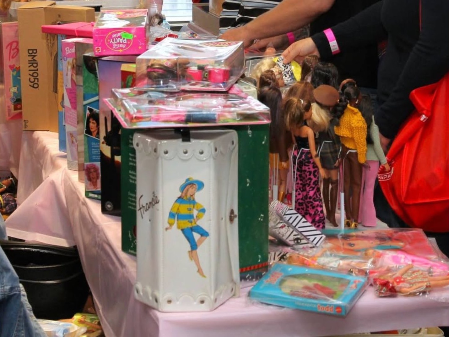 Boxed Barbies, a Francie case and dolls on a sales table at the September 2026 convention
