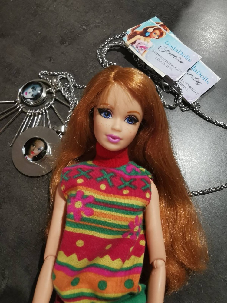 Redhead doll in front of DodaDolls Jewelry pendants